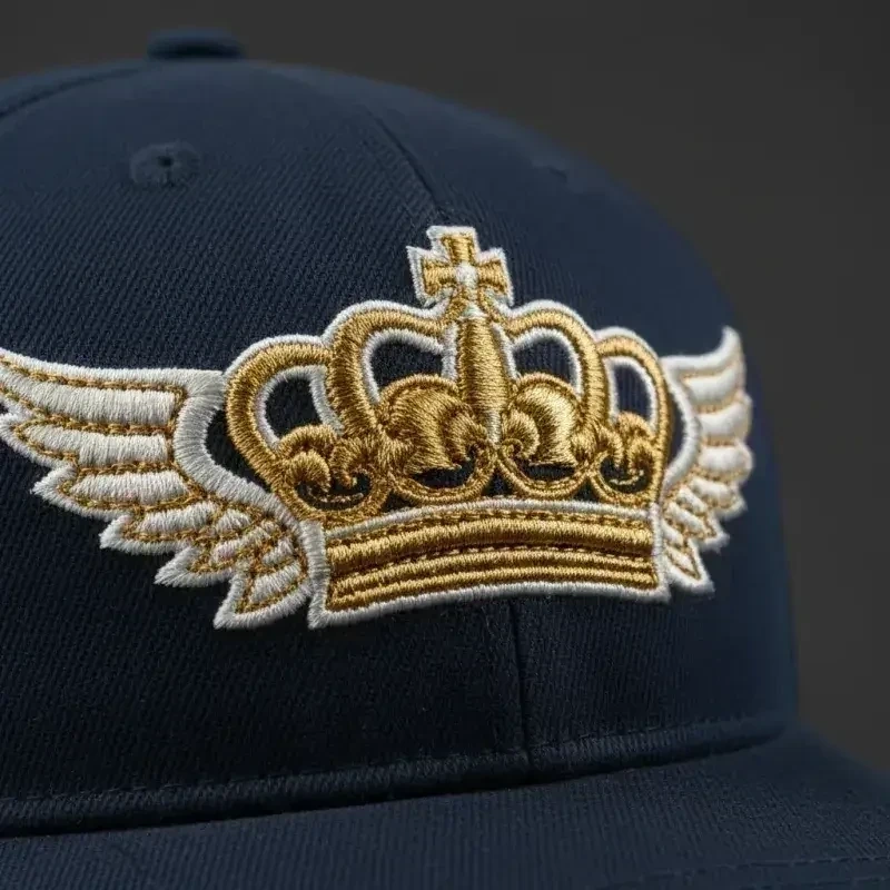 3D-Puff-Stickerei auf dunkler Cap — erhabene Stichstruktur in Gold und Weiß